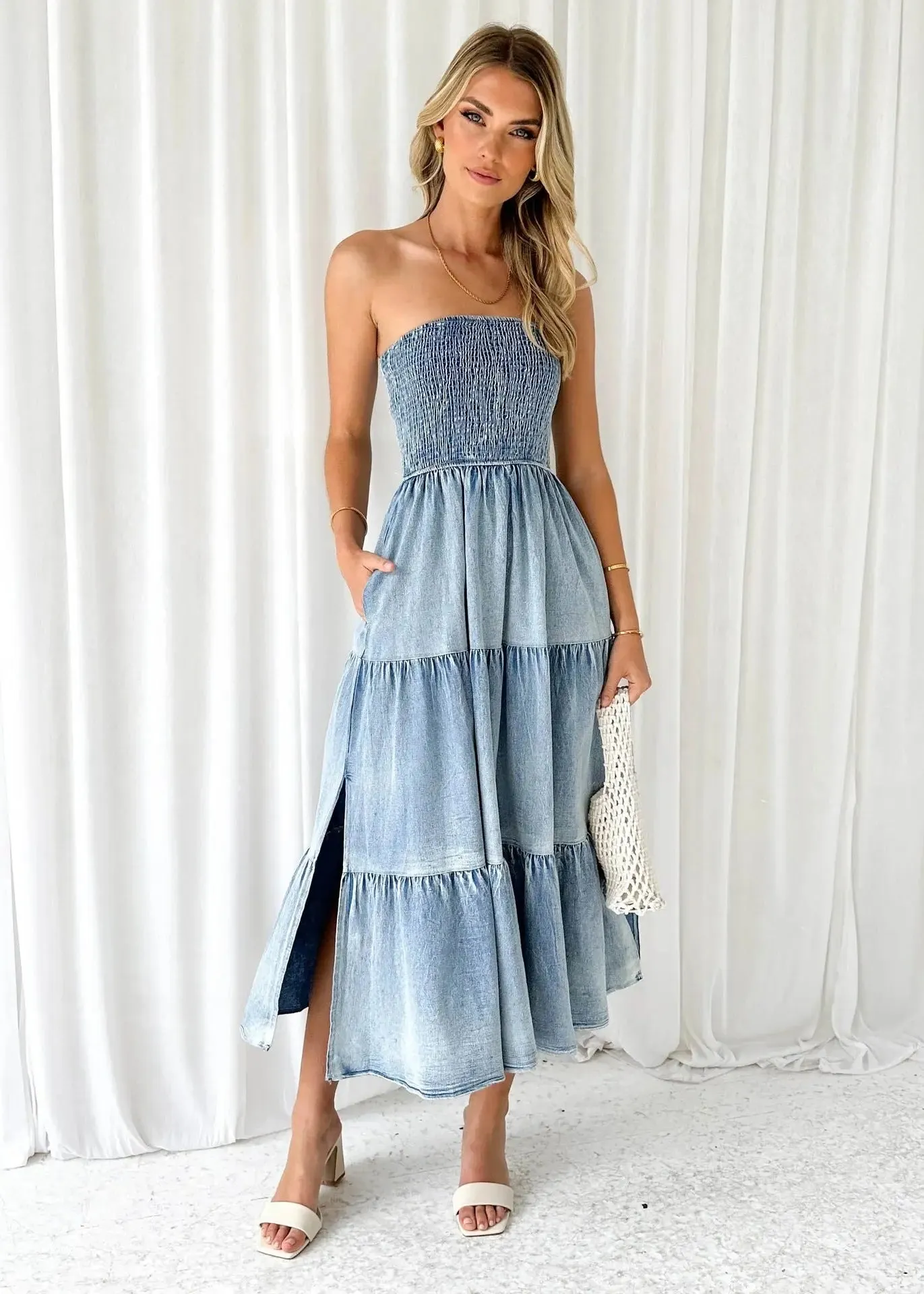 Denim strapless tiered maxi dress with a gathered bodice, side slit, and patchwork hem